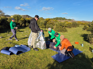 some first aiders treating simulated casualties outdoors on grassland